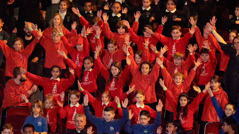 Students raising their arms with the music